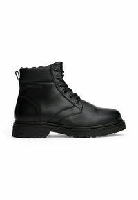 Botín negro de cuero hasta el tobillo con cordones en la parte delantera, cuello acolchado, suela resistente y tirador en el talón, con el logo "Tommy Jeans" en relieve en el lateral.
