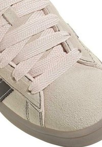 Baskets en suède beige clair avec surface texturée, lacets plats tressés roses et accent gris. Bout arrondi et détails de couture minimalistes.