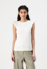 Vit ribbad ärmlös topp med scallop-lace detaljer vid axlarna, har en rund halsringning och en figurnära silhuett.
