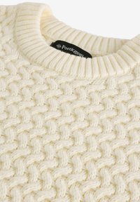 Cremefarbenes Strickpullover mit strukturiertem, gewebtem Muster und einem gerippten Rundhalsausschnitt. Schwarzes Etikett am Kragen zu sehen.