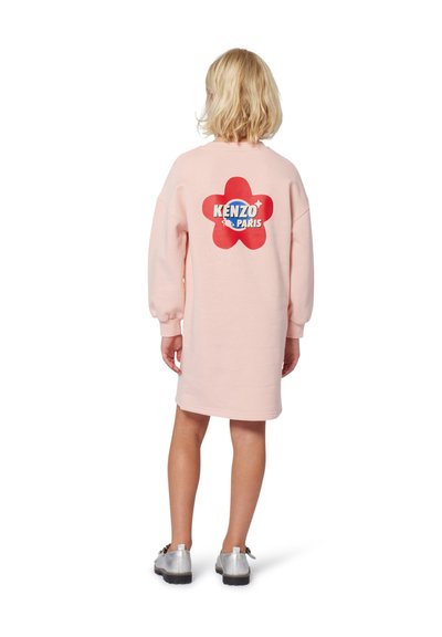Robe sweat rose à coupe oversize, avec un logo de fleur rouge et le texte "KENZO PARIS" au dos. Texture lisse, manches longues.