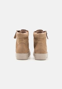 Bottines en daim tan avec une texture lisse, bout rond et fermeture éclair sur le côté. Semelle en caoutchouc avec un logo discret sur le talon.