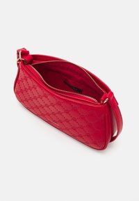 Sac à main en similicuir rouge avec une fermeture éclair. Présente un motif circulaire embossé et une texture lisse. Bretelle réglable incluse.
