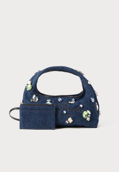 Denim-käsilaukku, jossa on kaareva kahva, koristeltu eri jalokivillä ja irrotettavalla lompakolla. Tummansininen väri, pehmeä rakenne ja vetoketjukiinnitys.