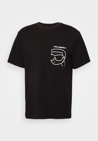 T-shirt en coton noir à manches courtes. L'avant présente un graphique blanc d'un visage portant des lunettes de soleil avec le texte 'KARL LAGERFELD' au-dessus.