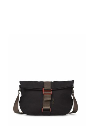Bolso bandolera negro con correa marrón ajustable, hebilla central marrón y logo sutil "KCB" en el frente.