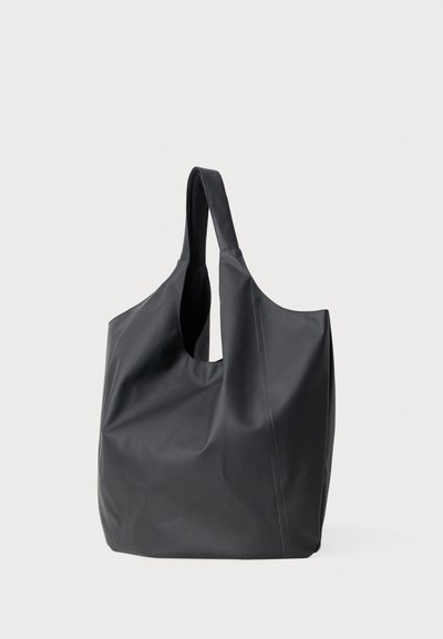 Borsa a tracolla nera realizzata in materiale flessibile e liscio. Presenta un'ampia apertura arrotondata, manici allungati e dettagli di cucitura minimi.