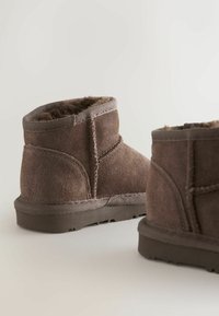 Pruunid sametist ankle-kingad pehme karvase voodriga, ümar kuju, tikandid ja tekstuuriga kummitald haardeks.