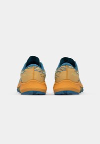 Hardloopschoenen met een blauw en geel kleurenschema, een gestructureerde bovenkant, versterkte hiel en een robuuste zool voor grip.