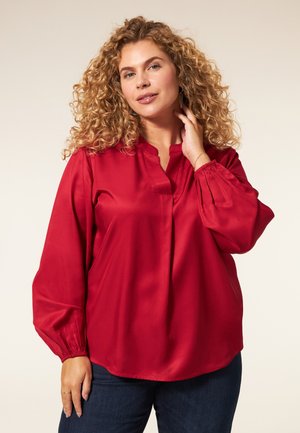 Rode satijnen blouse met een ontspannen pasvorm, v-hals en lange pofmouwen die bij de polsen zijn gathered. Smooth textuur en vloeiend ontwerp.