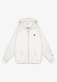 Felpa bianca con zip, con tasche frontali, piccolo logo di palma nera sul petto e testo sul polsino sinistro della manica.