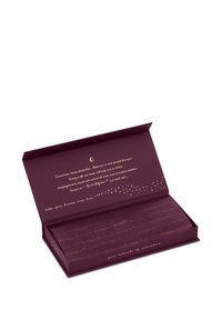 Boîte rectangulaire violette avec texte doré contenant des masques pour les yeux en soie pliés pour la relaxation et le sommeil de beauté.
