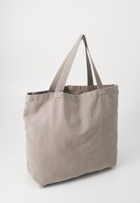 Borsa a tracolla in tela grigia con due manici in tessuto. Texture morbida e forma rettangolare, con bordi cuciti e senza loghi o motivi visibili.