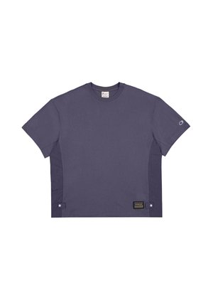 T-shirt violet à manches courtes en coton. Dispose d'un col rond, de panneaux latéraux et d'une étiquette avec du texte sur le bas à gauche.