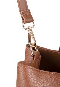 Borsa in ecopelle marrone con texture, dotata di hardware dorato, con una tracolla removibile e una tasca interna visibile. Inquadratura ravvicinata del fissaggio della tracolla.