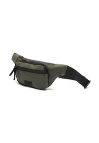 Borsa a vita compatta di colore verde oliva con cerniere nere e tracolla nera regolabile, appoggiata su una superficie bianca.