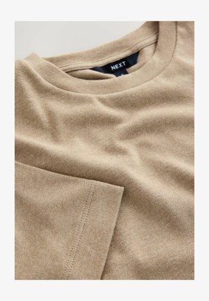 Bēša kokvilnas t-krekls ar apaļu kakla izgriezumu, īsām piedurknēm un gludu struktūru. Iezīmētas malas un etiķete kakla vietā.