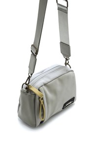 Bolso cruzado sintético gris con apertura con cremallera, correa ajustable, lazo de acento amarillo y detalle del logo negro en el lateral.