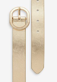 Ceinture en cuir doré avec une finition texturée, dotée d'une grande boucle ovale et de plusieurs trous ajustables le long de la sangle. La boucle et les bords sont lisses.