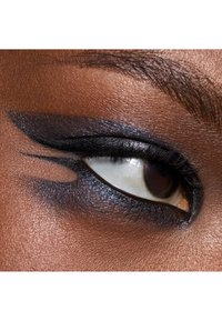 Close-up of an eye with dramatic black eyeliner and shimmery dark eyeshadow, highlighting the contours and texture of the skin around it.
