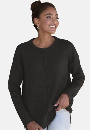 Black knitted sweater with a round neckline, ribbed cuffs, and side slits. Soft texture and relaxed fit. Worn with light blue jeans.