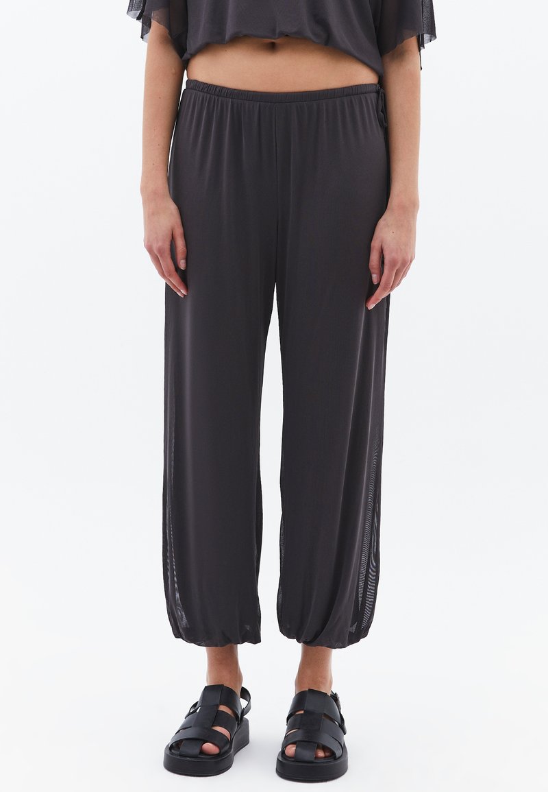 Lichte, donkergrijze cropped broeken met een elastische tailleband en zijinzetten van mesh. Draag ze met zwarte sandaaltjes met banden. Gladde textuur.