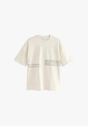 Lühikeste varrukatega koorevärvi puuvillane T-särk, millel on prinditud tekst: "RUE CRÉMIEUX PARIS 75112" ja "NOUVEAUX PROJECTS" halli värviga.