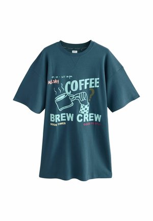 Stort turkos t-shirt i bomull med ett grafiskt tryck av en kaffekopp och text i vitt, rosa och grönt.