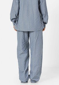 Blauwe en witte gestreepte outfit met een losvallend shirt met wijd uitlopende mouwen en bijpassende wijd-uitlopende broek, gemaakt van zachte stof.