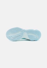 Lys blå sneakersål med teksturerede riller, der har en hvid mellem sålsektion. Designet inkluderer et logo nær hælen og en glat finish.