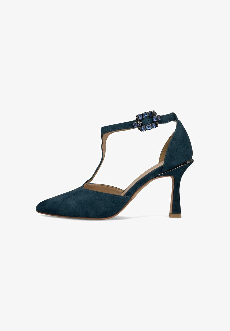 Granatowe zamszowe buty na wysokim obcasie z ostrym noskiem i designem T-strap. Posiadają dekoracyjną klamrę z kamieniem na pasku wokół kostki.