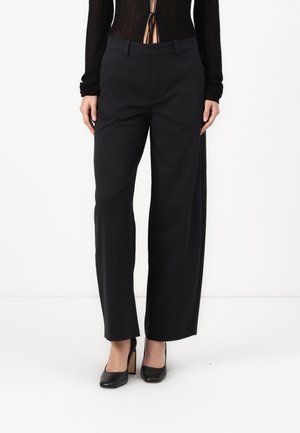 Black wide-leg trousers with a smooth texture, featuring a flat front, belt loops, and pockets. Worn with black high-heeled shoes.