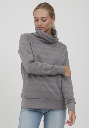 Felpa grigia con collo a cowl, dettaglio dei bottoni e motivo a zigzag testurizzato. Maniche lunghe e vestibilità rilassata. Materiale misto cotone.