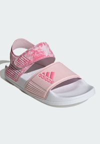 Sandalias de slide rosas con un diseño de tira veteada, suelas de goma texturizadas, correas ajustables de velcro y una suela blanca con el logotipo de Adidas.