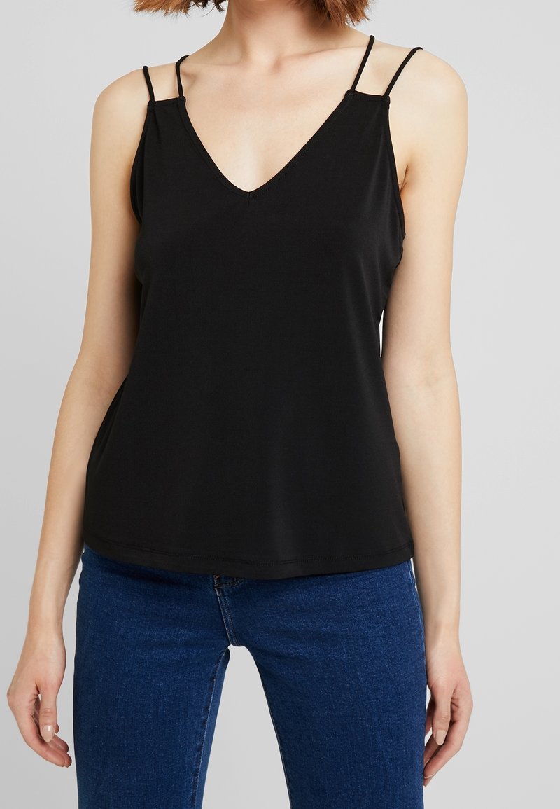 Svart v-ringad linne med tunna, justerbara axelband, tillverkat av ett mjukt, elastiskt tyg. Søröning är rak, och passformen är avslappnad.