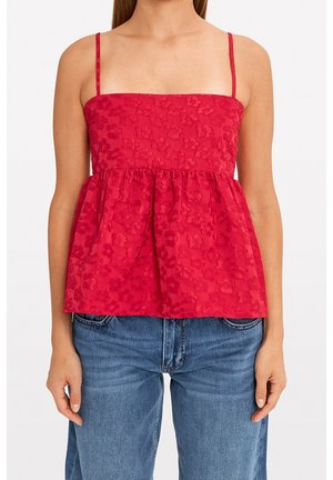 Rode peplumtop met dunne bandjes, gewatteerd bloempatroon en een vierkante halslijn, gecombineerd met blauwe denim jeans.