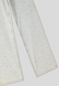 Jeans in denim azzurro chiaro con design a gamba dritta, decorati con piccole borchie argentate disposte in un motivo sparso su tutto il tessuto.