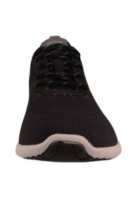 Schwarzer Sportschuh mit atmungsaktivem Mesh-Obermaterial, strukturierten Oberflächen und kontrastierender weißer Sohle mit schwarzen Akzenten. Mit Schnürdesign.