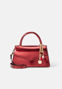 Red patent leather handbag with a structured shape, top handle, detachable shoulder strap, and gold chain accents with colorful charms.