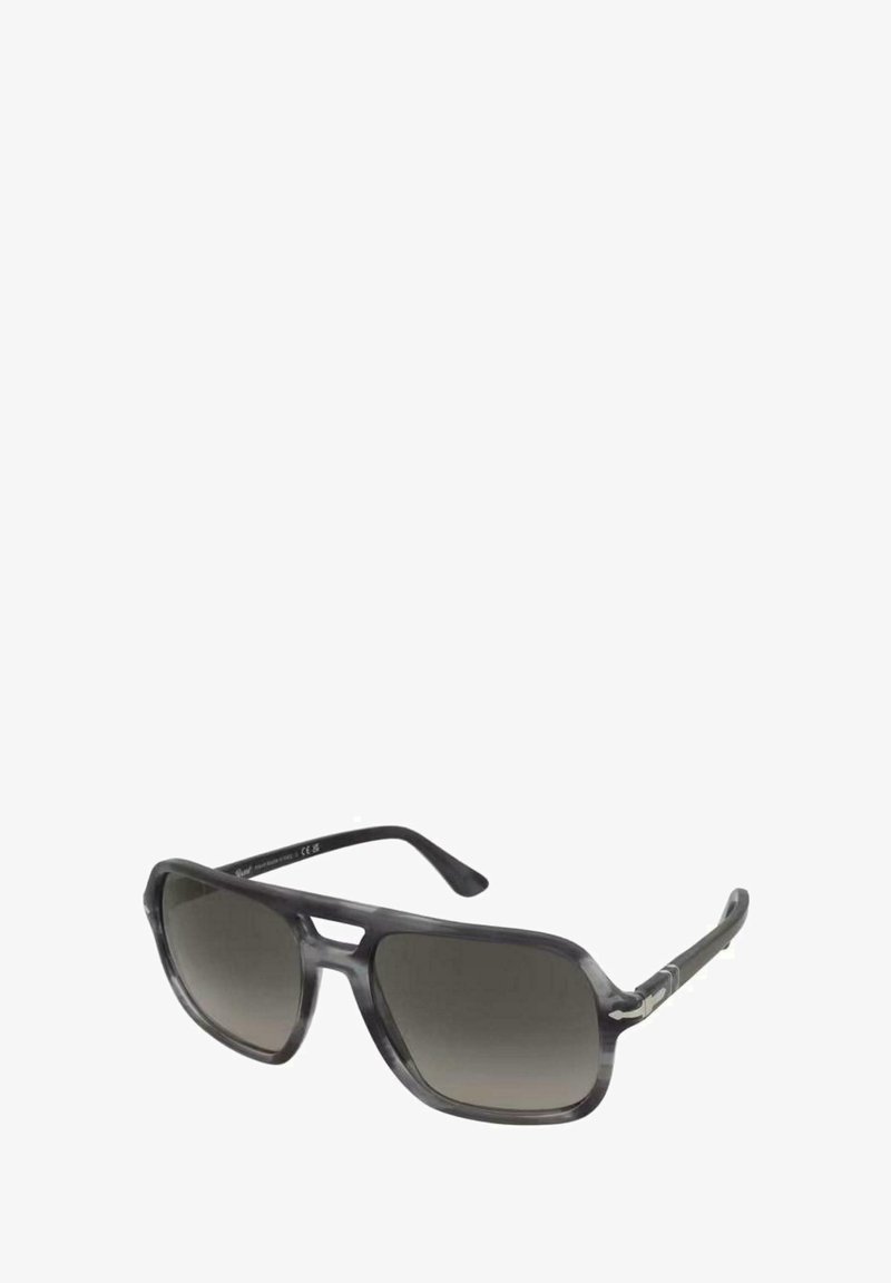 Sluneční brýle se šedým, poloprůhledným rámem a tmavými gradientními skly, s jedinečným úhlovým tvarem a stříbrnými doplňky na stranách.