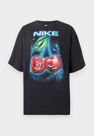 T-shirt noir Nike avec un graphisme de cerises lumineuses, l'une marquée "90" et l'autre avec un swoosh Nike, sous le logo Nike.