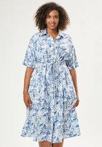 Abito camicia con maniche corte, caratterizzato da un motivo a foglie blu e bianche, una vita elastica e un design a gonna svasata.
