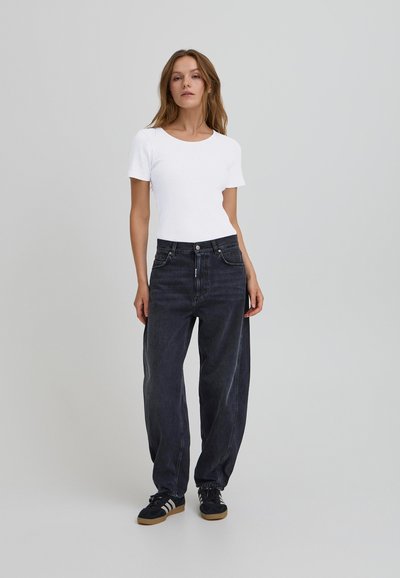 Melni plaša kāju džinsi ar augstu jostasvietu, klasisku piecu kabatu dizainu un nelielu izbalēšanu. Saskaņoti ar pieguļošu balto īsām piedurknēm kreklu.