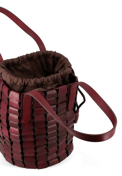 Borsa a secchiello in pelle borgogna intrecciata con interno in tessuto marrone a coulisse, dotata di due tracolle e dalla forma rotonda.