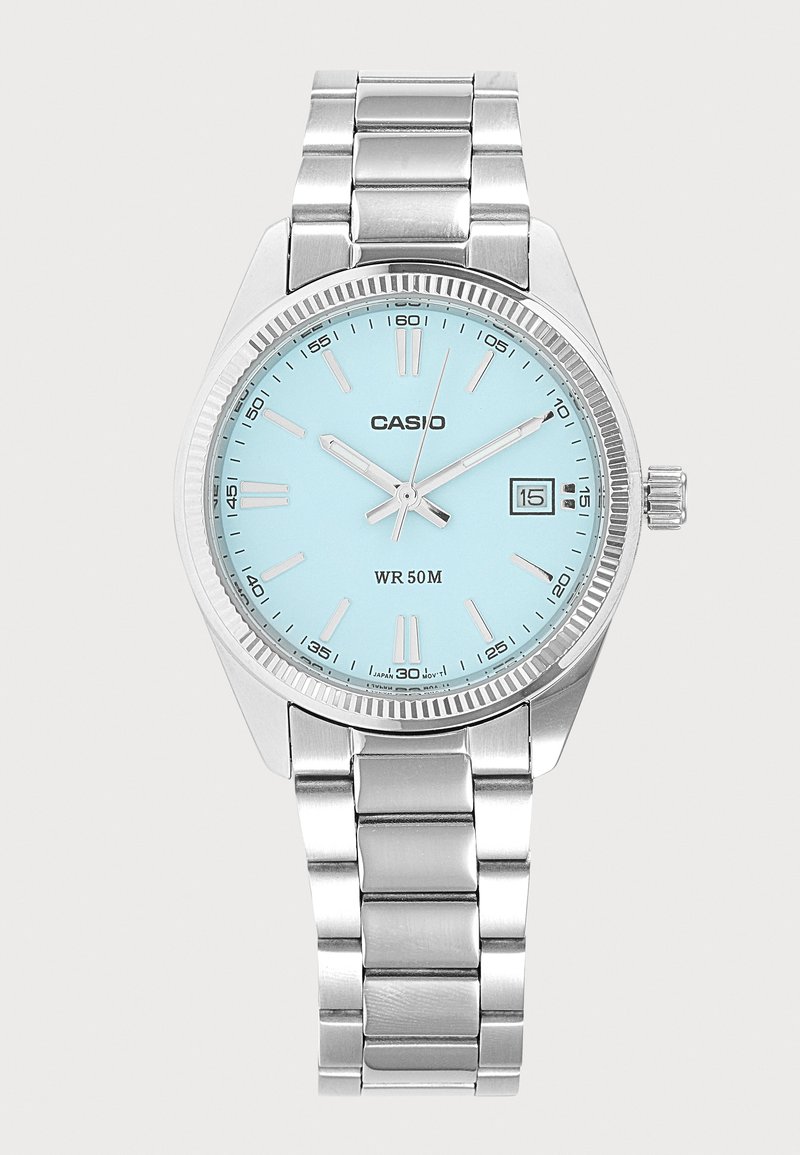 Montre-bracelet Casio en métal argenté avec cadran bleu clair, trois aiguilles indiquant 10:09:03, guichet date à 3 heures, et résistance à l'eau jusqu'à 50 mètres.