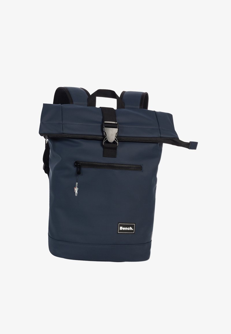 Sac à dos étanche navy avec un design à rabat, sangles noires réglables, poche zippée à l'avant et patch logo. Présente des accents en métal argenté.