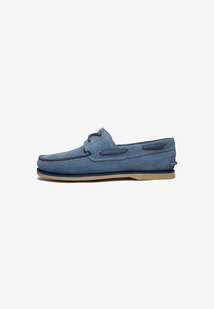 Blaue Wildleder-Loafer mit abgerundetem Zehenbereich, Schnürakzenten und einer kontrastierenden tannfarbigen Sohle. Glatte Textur mit gestickten Details im Obermaterial.