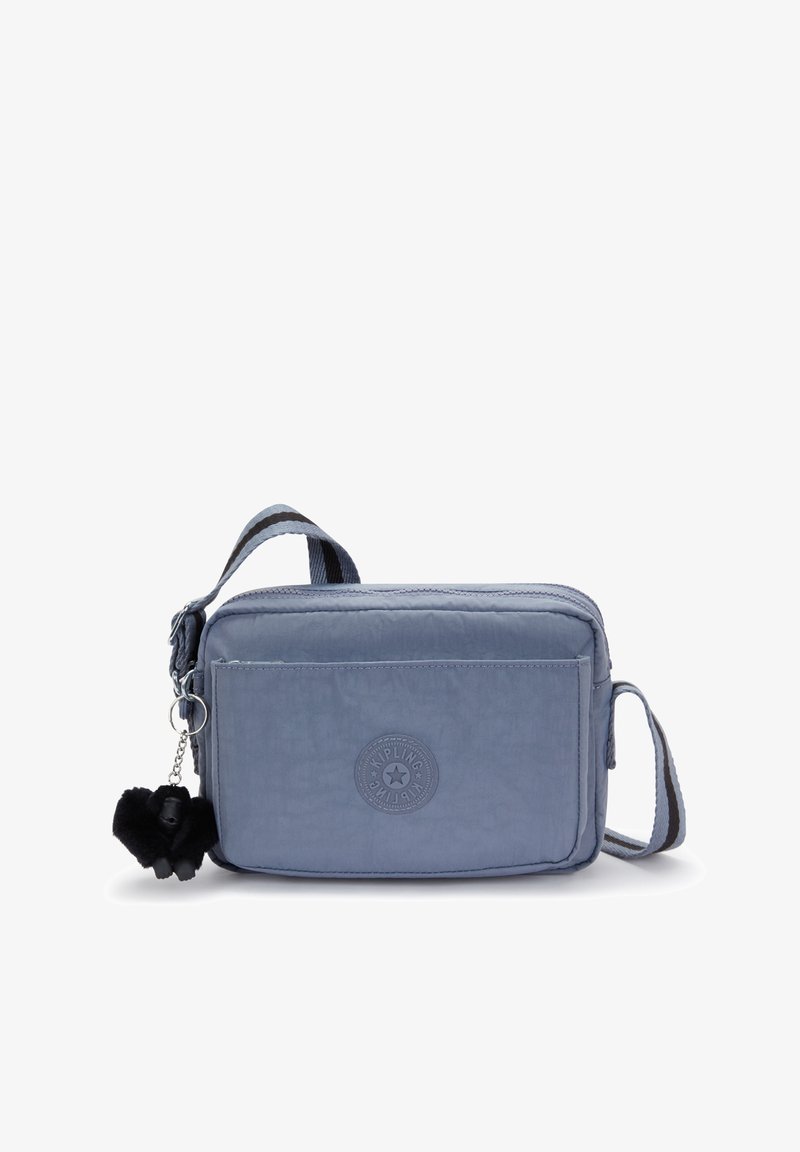 Jasnoniebieska torba na ramię wykonana z teksturowanego nylonu, z przednią kieszenią na zamek, regulowanym paskiem i czarnym brelokiem w kształcie pom-poma.