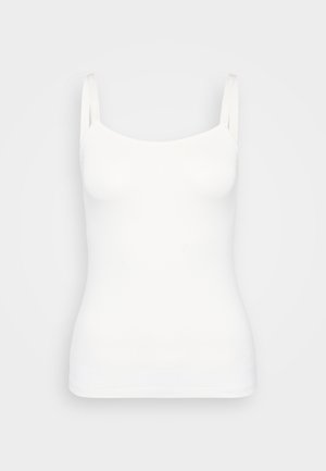 Bílé tílko vyrobené z měkké tkaniny, s tenkými ramínky a přiléhavým střihem, s hladkou a elastickou texturou.