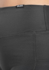 Leggings neri realizzati in tessuto elasticizzato, con una texture liscia, una vita con logo e cuciture doppie per una maggiore durata.